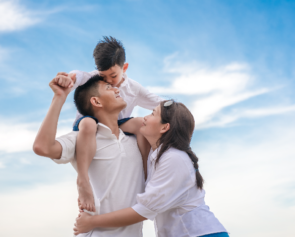 Asian family at the beach hugging