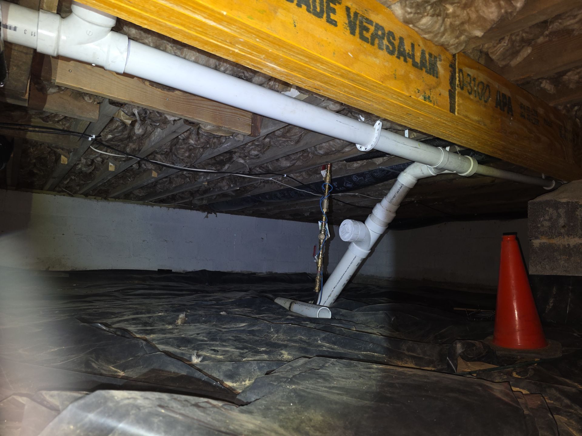 crawl space with white pipes running through the space