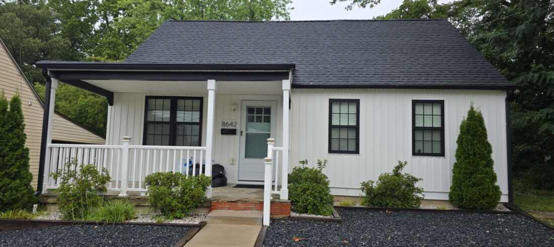 white house with black roof and a front porch